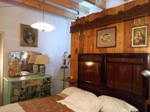 1 dormitorio con cabecero de madera y 1 cama en La casa di Donna Anna, en Squinzano