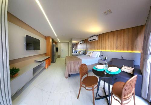 a hotel room with a bed and a table and chairs at Unity by Hosppedar in Penha