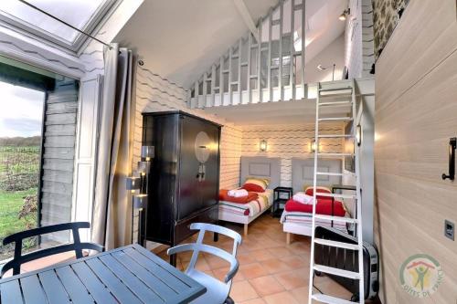 a small room with bunk beds and a table and chairs at La petite salmonais in Saint Malo