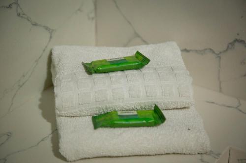 Dos toallas en un mostrador con una botella verde. en Pousada Serra & Jardim en Bom Jardim da Serra