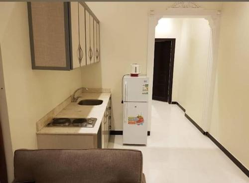 a kitchen with a stove and a refrigerator at أجنحة ميثاق الفندقية in Riyadh