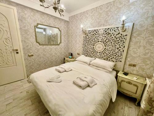a bedroom with a white bed with two towels on it at Silver 34 Boutique in Tbilisi City