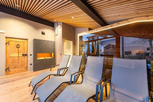 a group of chairs in a room with a fireplace at Naturoase Stegerhof Apt Margerite in Trodena