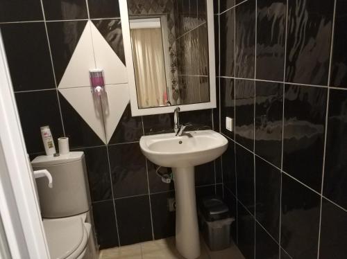a bathroom with a sink and a toilet and a mirror at Gvar Hotel ANTALYA in Antalya
