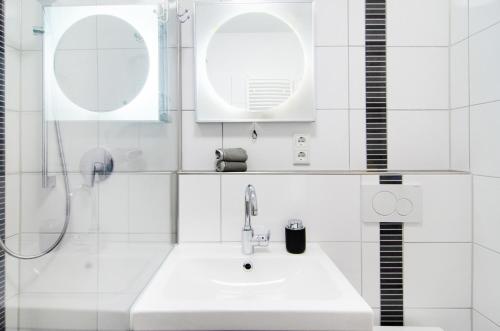 ein weißes Bad mit einem Waschbecken und einer Dusche in der Unterkunft Lotsenbude in Wilhelmshaven