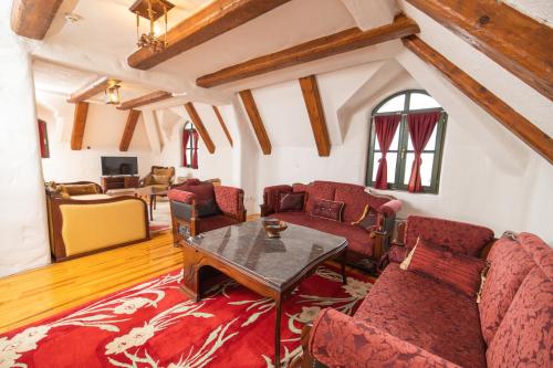 uma sala de estar com mobiliário vermelho e uma mesa em Ethno Village Stanisici em Bijeljina