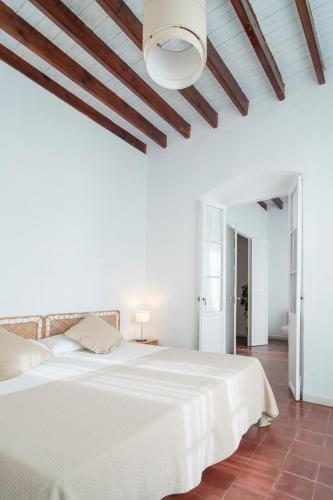 a white bedroom with a white bed and a ceiling at La Casa del Convento in Villamanrique de la Condesa