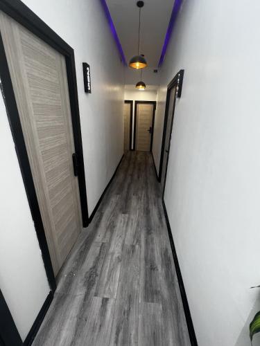 a hallway with white walls and wooden floors and doors at VOY Hostales - Oriente in Viña del Mar