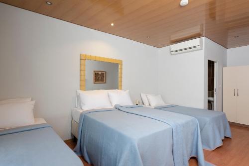 two beds in a room with white walls and wooden ceilings at Gvar Hotel ANTALYA in Antalya