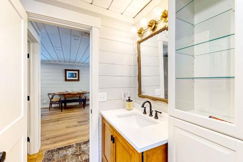 a bathroom with a sink and a mirror and a table at Grouse's Nest in Rangeley