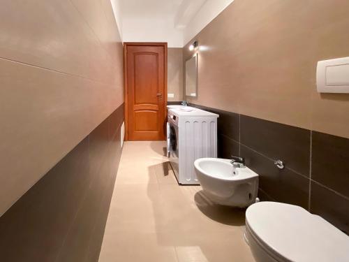 La salle de bains est pourvue de toilettes blanches et d'un lavabo. dans l'établissement SUN LIGHT, à Tortolì