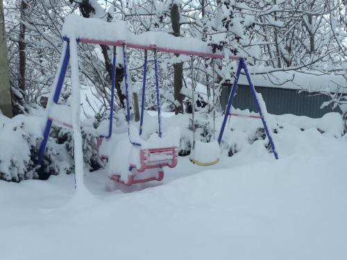 a swing in a yard covered in snow at Ferienhaus Heerlichkeit in Löffingen