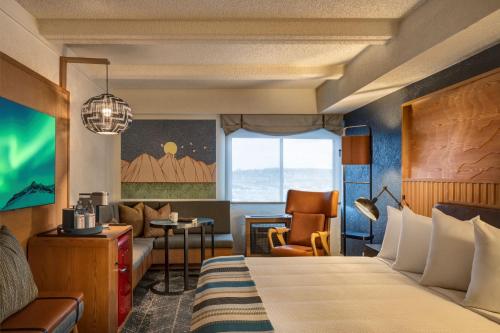a hotel room with a bed and a chair at Aviator Hotel Anchorage in Anchorage
