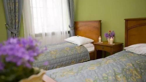 a bedroom with two beds and a window with flowers at Pałac Borowa in Borowa