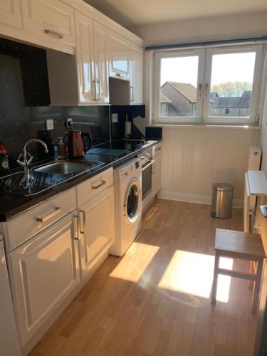 uma cozinha com um lavatório e uma máquina de lavar roupa em Modern One Bedroom Apartment em Lossiemouth