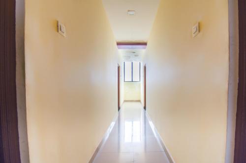 an empty hallway with white walls and a long aisle at OYO Hotel Kanyaratna And Lodging in Chas