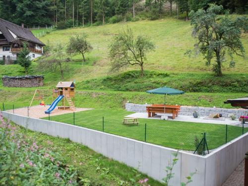 un parque con parque infantil con mesa de picnic y banco en Ferienwohnungen Lioba Huber, en Bad Peterstal-Griesbach