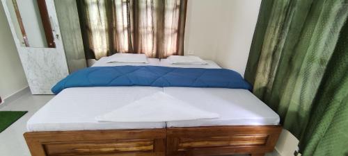 um quarto com uma cama com almofadas azuis em Kaziranga Balaji homestay em Kaziranga