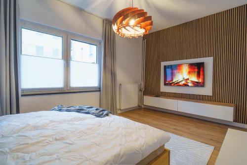 a bedroom with a bed and a tv on a wall at Apartment Innenstadt- Zentral und Exklusiv in Bestlage, Stilvolles Ambiente, alles zu Fuß erkunden in Braunschweig