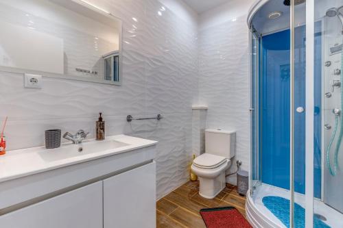 uma casa de banho com um WC, um lavatório e um chuveiro em Quiet View Rooms em Porto
