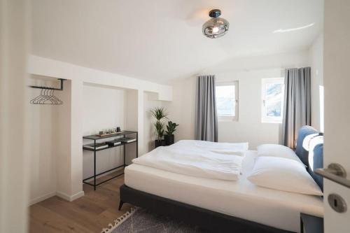 - une chambre avec un grand lit blanc et une fenêtre dans l'établissement LUXE VISTA City Apartment Algund, à Lagundo