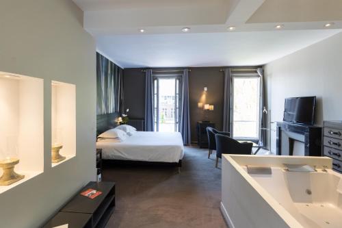 a hotel room with a bed and a bathroom at Domaine de Joinville in Eu