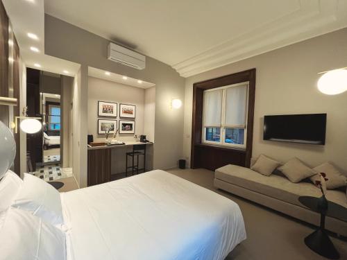 - une chambre avec un lit blanc et un canapé dans l'établissement My Milano Charming & Luxury Rooms, à Milan