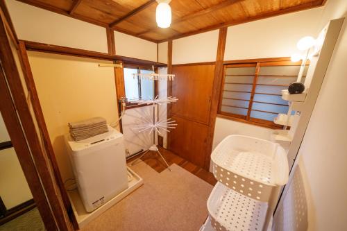 Baño pequeño con aseo y lavamanos en LARGE HOUSE Lodging Hidamari, en Tokio