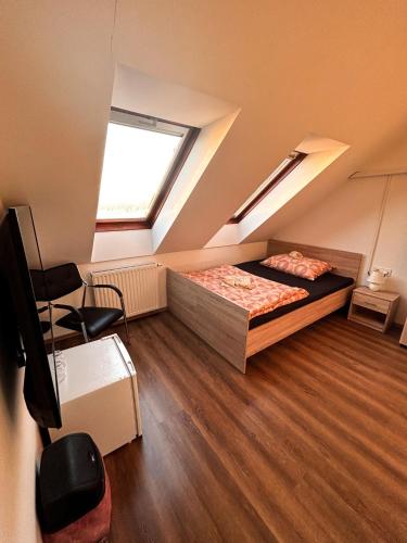 een slaapkamer op zolder met een bed en een raam bij Malom Panzió in Kiskunfélegyháza