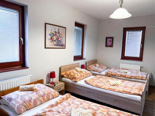 Malom Panzió في كيسكونفيليغيهازا: غرفة بأربعة أسرة في غرفة بها نوافذ