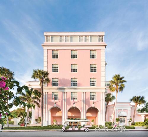 a pink building with a cart in front of it at The Colony Hotel in Palm Beach