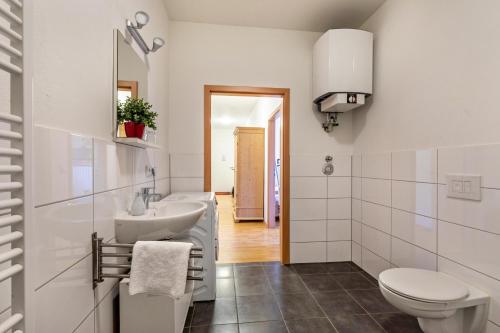 a white bathroom with a sink and a toilet at Ferienwohnung Rechts in Welden