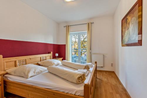 two beds in a bedroom with a red wall at Ferienwohnung Rechts in Welden