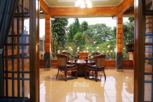 a dining room with a table and chairs at Villa Tentram Puncak, 6 Kamar, Billiar, Karaoke in Paragajen