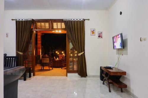 a living room with a door open to a living room at Villa Tentram Puncak, 6 Kamar, Billiar, Karaoke in Paragajen