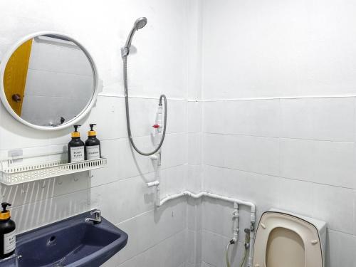 a bathroom with a shower and a sink and a mirror at Ao Luek Homie Homestay in Krabi town