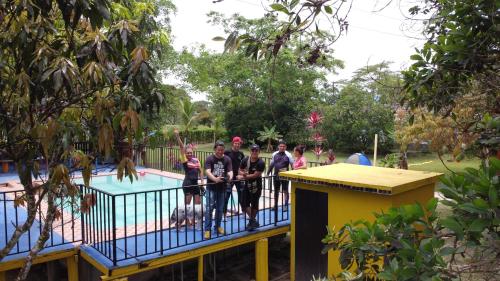 un grupo de personas de pie en un balcón junto a una piscina en Amalaya Hostel, en Restrepo