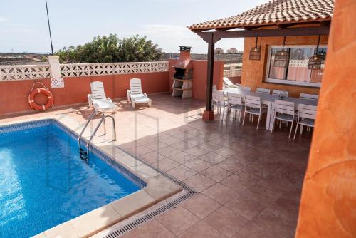 コラレホにあるVilla Atlantic Ocean Private Pool Corralejo By Holidays Homeのパティオ(プール、テーブル、椅子付)