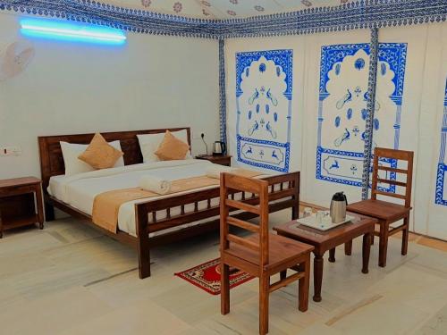 a bedroom with a king sized bed and a table at Heritage Luxury Camp in Sām
