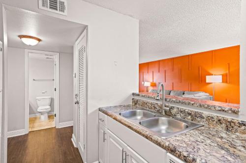 a kitchen with a sink and a bathroom with a bed at Avenida in Tampa