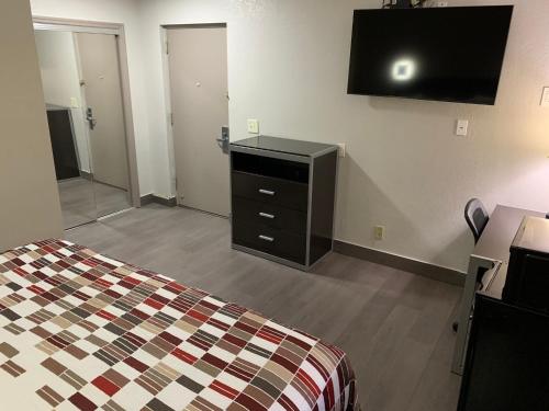 a bedroom with a bed and a dresser and a television at Red Roof Inn Copiague in Copiague