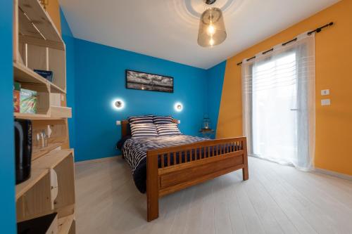 a bedroom with a bed with a blue wall at Bon Accueil in Saint Malo