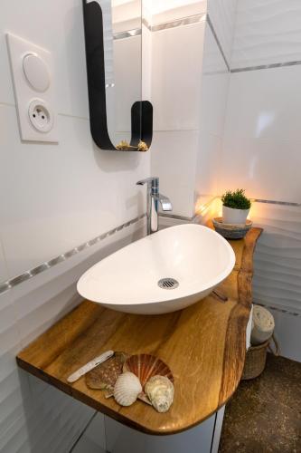 ein Badezimmer mit einem weißen Waschbecken und einem Spiegel in der Unterkunft Bon Accueil in Saint-Malo