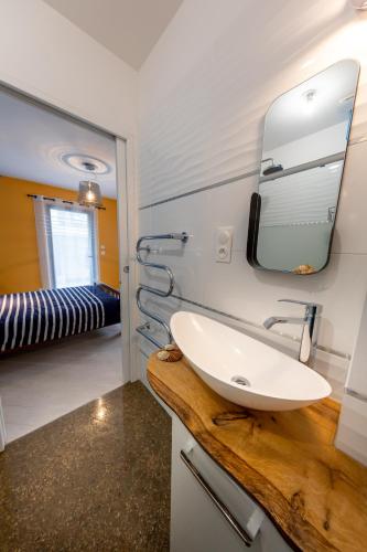 une salle de bain avec un lavabo et un miroir dans l'établissement Bon Accueil, à Saint-Malo