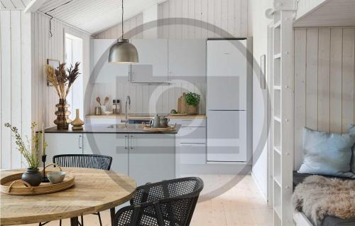 uma cozinha com uma mesa e cadeiras de madeira e uma sala de jantar em 3 Bedroom Stunning Home In Hrve em Hørve