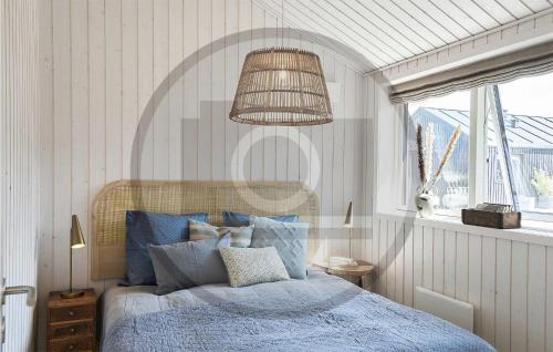 um quarto com uma cama azul e um lustre em 3 Bedroom Stunning Home In Hrve em Hørve