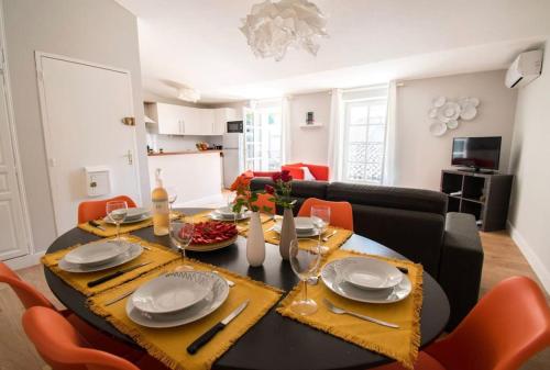 a dining room with a table with plates and chairs at Le Saint Gimer - Vue sur la Cité Médiévale - Climatisation in Carcassonne