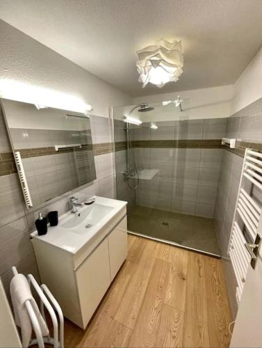 une salle de bain avec un lavabo blanc et une douche dans l'établissement Le Saint Gimer - Vue sur la Cité Médiévale - Climatisation, à Carcassonne