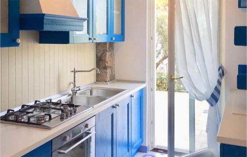 a kitchen with blue cabinets and a sink and a window at Beautiful Home In Anacapri With Kitchen in Anacapri