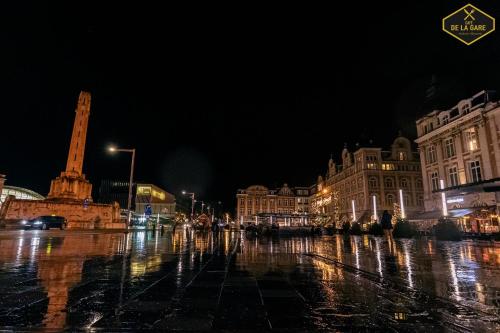 a city street at night with a monument in the distance at Hotel Malon in Leuven